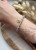 Elegancka szara bransoletka Lazuri – biżuteria z agatem i złotem do stylowej kreacji.