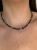 Zbliżenie na choker MAMORI ze srebrnym hematytem i zawieszką półksiężyc Lunula.