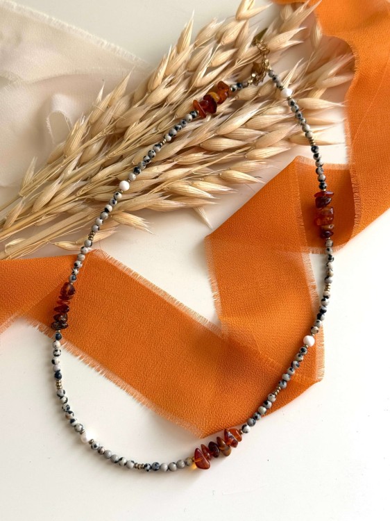 Naszyjnik AMBERA prezentowany na płasko – bursztyn w formie sieczki, jaspis dalmatyński i perły słodkowodne ze złotymi detalami. Elegancka, nowoczesna biżuteria handmade.