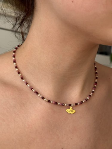 Naszyjnik MALVA z zawieszką liścia miłorzębu i perłą na dekolcie modelki
