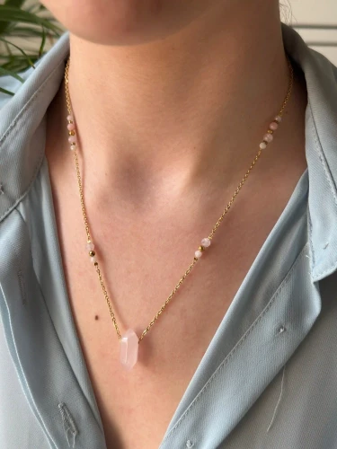 Naszyjnik KIMI na złotym łańcuszku z kryształem kwarcu różowego na dekolcie.