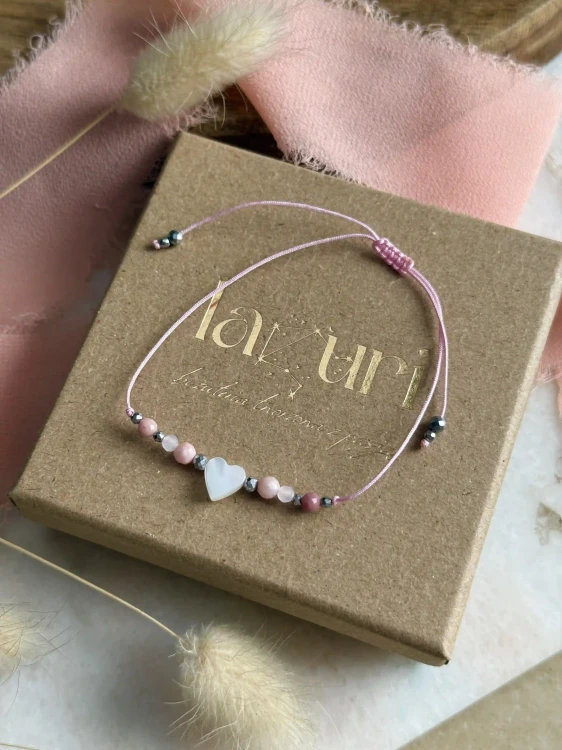 Zbliżenie na kamienie naturalne: różowy opal, rodonit i srebrny hematyt w biżuterii.