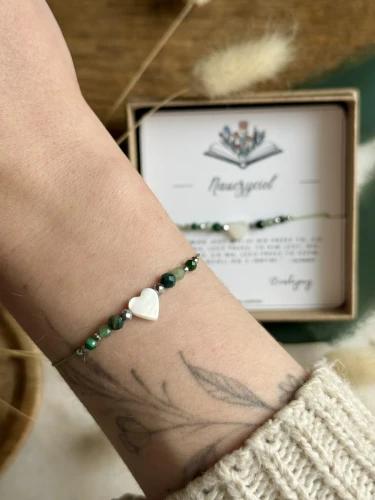 Bransoletka talizman na zielonym sznurku z sercem z masy perłowej i hematytem.