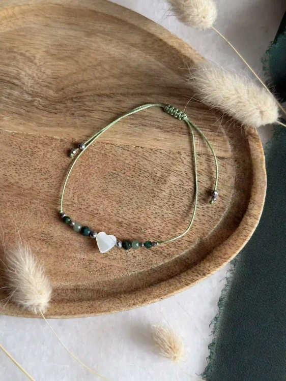 Zbliżenie na zielone kamienie naturalne: jadeit, awenturyn i perłowe serce w bransoletce.
