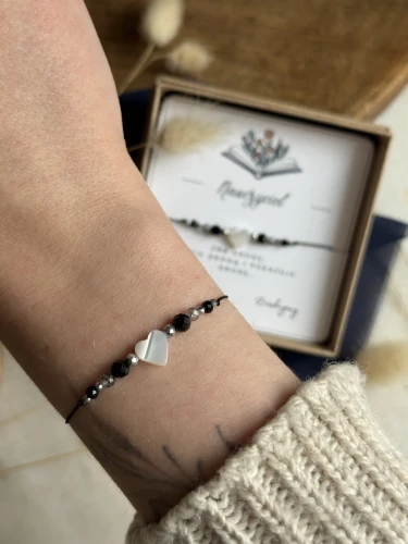 Talizman siły i ochrony: bransoletka na czarnym sznurku z masą perłową.