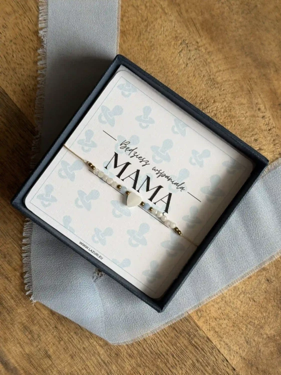 Otwarte granatowe pudełko prezentowe Lazuri z personalizowaną biżuterią z okazji Baby Shower.