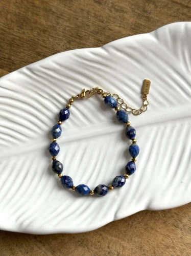 Luksusowa bransoletka Olive Premium z lapis lazuli w kształcie oliwek i hematytu na jasnym tle.