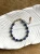 Luksusowa bransoletka Olive Premium z lapis lazuli w kształcie oliwek i hematytu na jasnym tle.