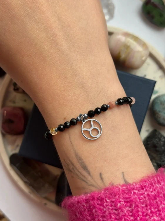 Ochronna bransoletka dla Byka ze srebrną zawieszką zodiakalną na nadgarstku modelki.
