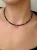 Zbliżenie na choker MAMORI ze złotym hematytem i zawieszką lunula
