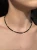 Zbliżenie na choker MAMORI ze srebrnym hematytem i zawieszką półksiężyc Lunula.