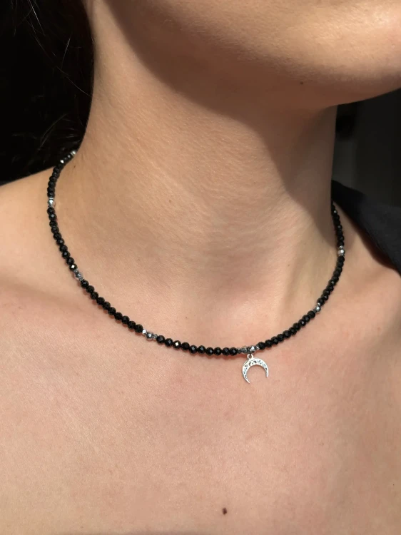 Zbliżenie na choker MAMORI ze srebrnym hematytem i zawieszką półksiężyc Lunula.